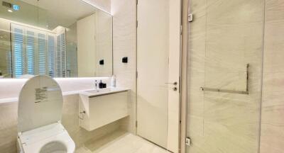 Modern bathroom with light beige tiles and sleek fixtures.