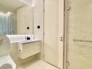 Modern bathroom with light beige tiles and sleek fixtures.