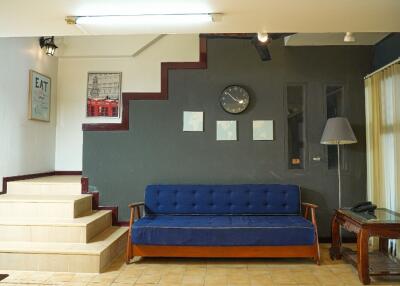 Living room with staircase, couch, and wall decorations