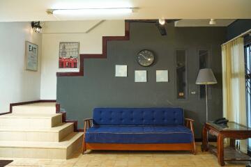 Living room with staircase, couch, and wall decorations