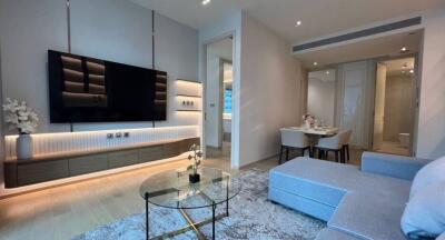 Modern living room with adjacent dining area and large wall-mounted TV