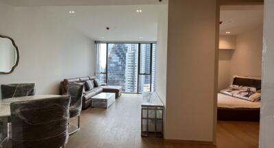 Modern living room with dining area and view of a bedroom