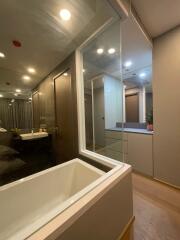 Modern bathroom with bathtub, large mirrors, and wooden doors