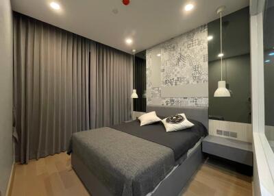 Modern bedroom with bed, bedside tables, and pendant lights