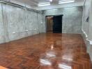 empty room with wooden floor and concrete walls
