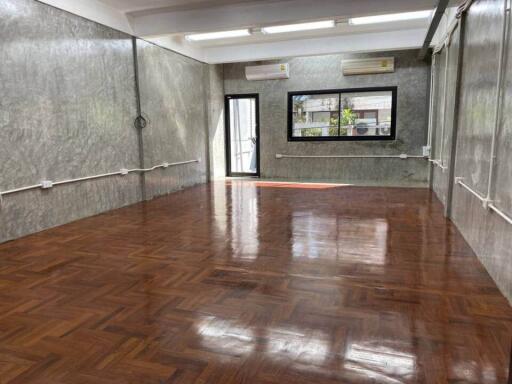 Spacious, empty living area with wooden flooring and large windows