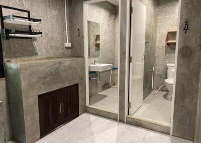 Modern bathroom with concrete walls and separate shower area