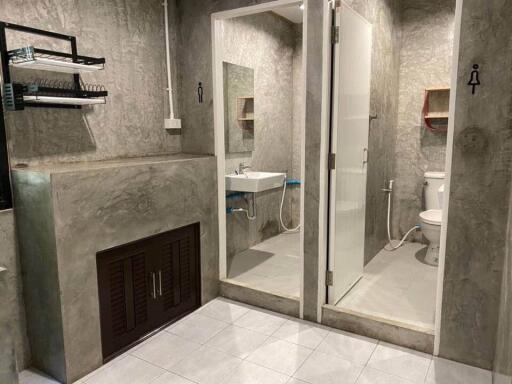 Modern bathroom with concrete finishes, glass shower enclosure, and white fixtures
