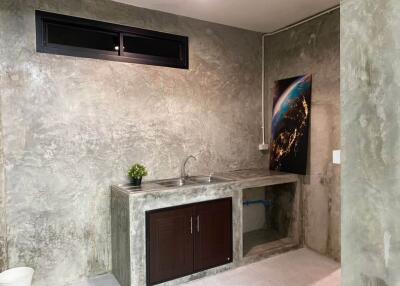 minimalist kitchen with concrete walls and modern artwork