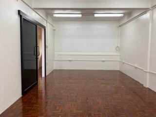 Empty room with wooden parquet flooring and a black sliding glass door