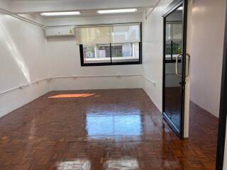 Empty room with parquet flooring and large window