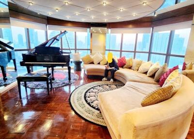 Spacious living room with large windows, grand piano, and a curved sectional sofa