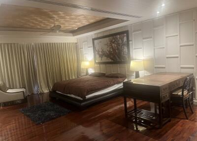 Spacious bedroom with wooden flooring and cozy lighting