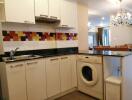 Modern kitchen with colorful backsplash and integrated appliances