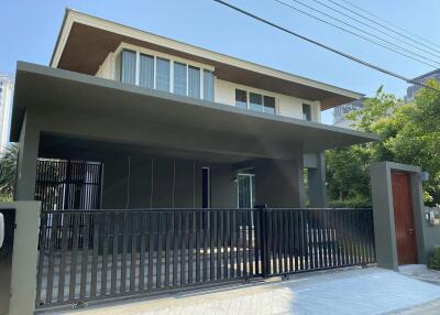 Modern two-story house with a gated entrance and carport