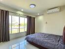 Well-lit bedroom with large window and air conditioning unit