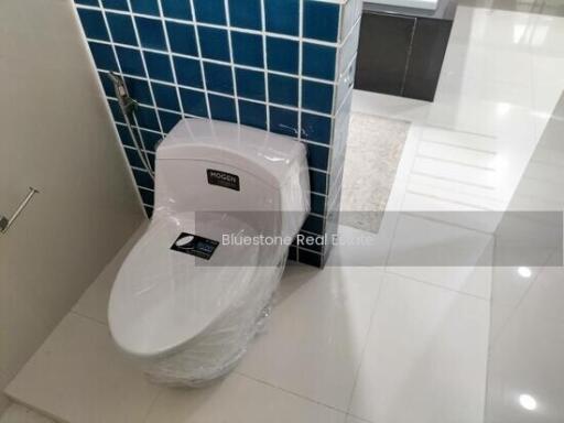 Modern bathroom with new toilet and tiled wall