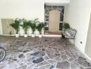 Property entrance with stone flooring, potted plants, and a decorative bench