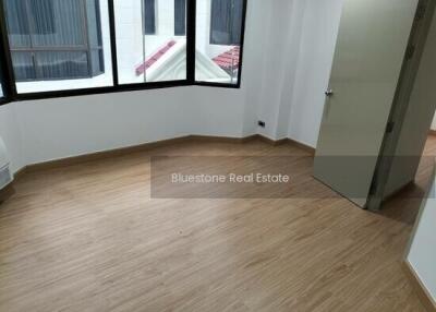Empty bedroom with wooden flooring and large window
