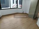 Empty bedroom with wooden flooring and large window