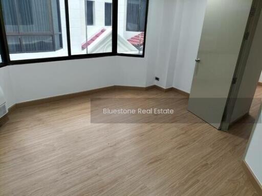 Empty bedroom with wooden flooring and large window