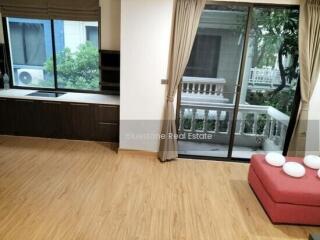 Spacious living area with wooden flooring and large windows