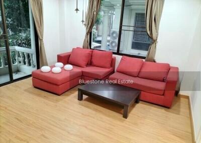 Spacious living room with red sofas and hardwood flooring