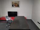 Modern office space with desk, chair, TV, and art piece on the wall