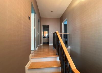 Staircase with wooden railing and hallway