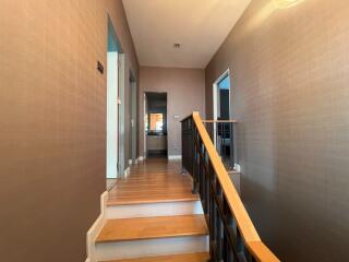 Staircase with wooden railing and hallway