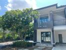 Modern two-story house with large tree in front yard