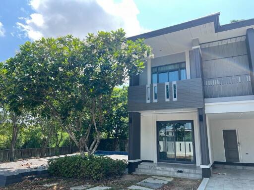 Modern two-story house with large tree in front yard