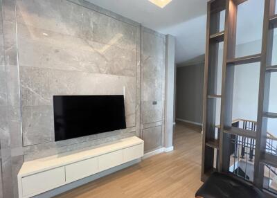 Modern living room with a wall-mounted TV and a contemporary divider.