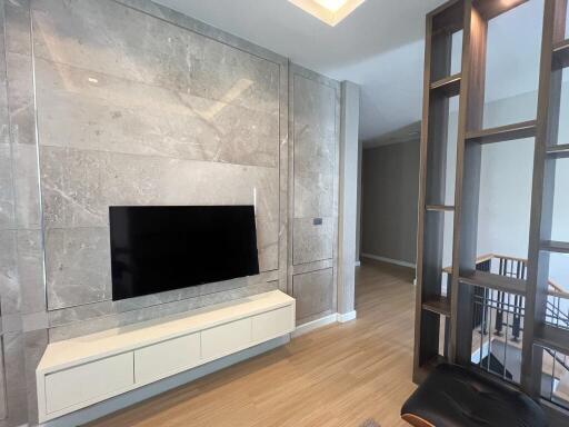 Modern living room with a wall-mounted TV and a contemporary divider.