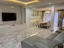 Modern living room with TV, dining area, and marble flooring