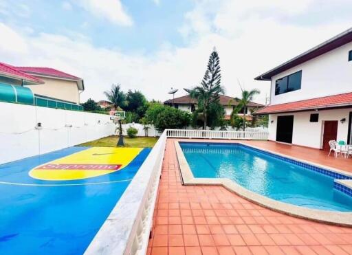 A luxurious backyard with swimming pool and basketball court