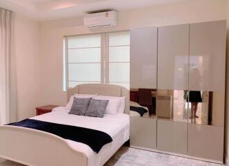 Modern bedroom with bed, pillows, wardrobe, and air conditioner