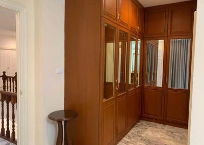 Closet area with wooden cabinets and mirrors
