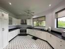 Spacious modern kitchen with white cabinetry and ample natural light