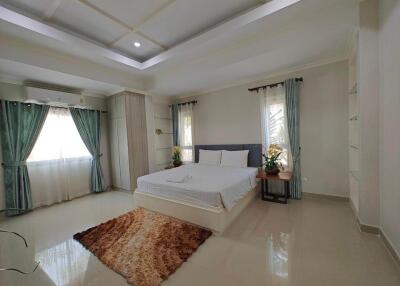 Spacious bedroom with a large bed, modern decor, and ample natural light