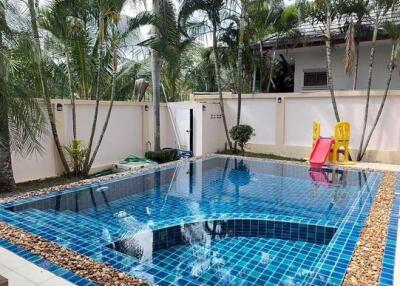 private swimming pool area with a slide and surrounding palm trees