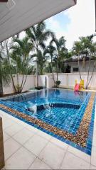 private swimming pool area with a slide and surrounding palm trees