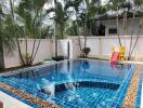 private swimming pool area with a slide and surrounding palm trees