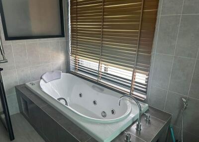 Modern bathroom with bathtub and window blinds