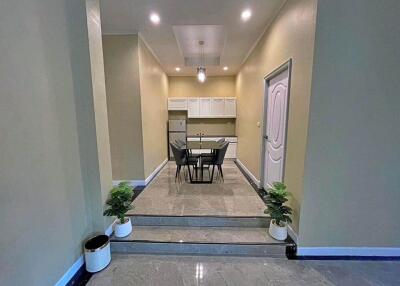 Modern dining area with a table and chairs, refrigerator, and decorative plants