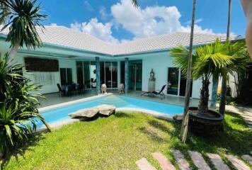 Outdoor view of a residential property with a swimming pool and garden