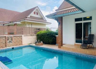 Outdoor swimming pool with seating area and surrounding buildings