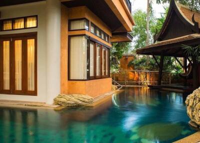 luxurious outdoor pool area with adjacent building and garden