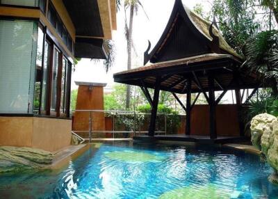 Elegant swimming pool with tropical landscaping and traditional gazebo