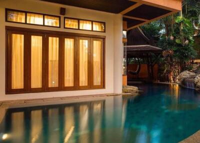 Outdoor pool area with wooden doors and lush greenery